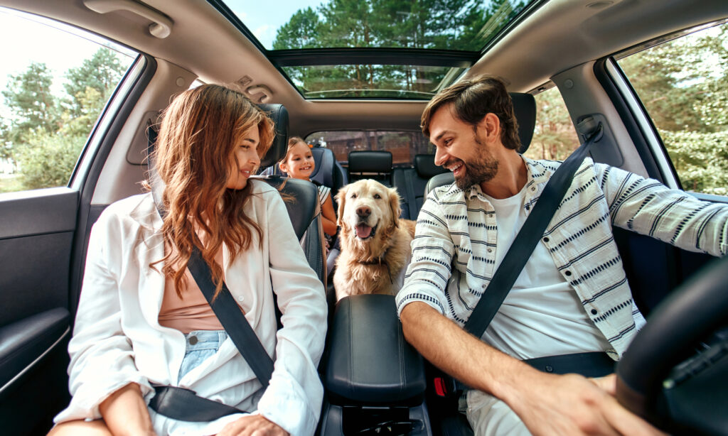 A smiling family sits in a car with their golden retriever, highlighting pet ownership and opportunities in the growing pet services industry.